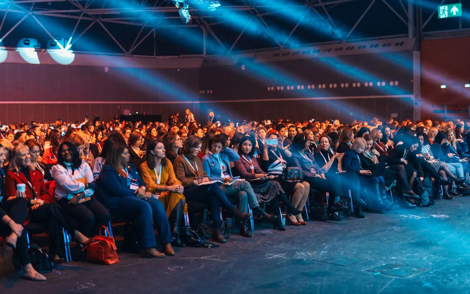 Conference audience seated under stage lighting